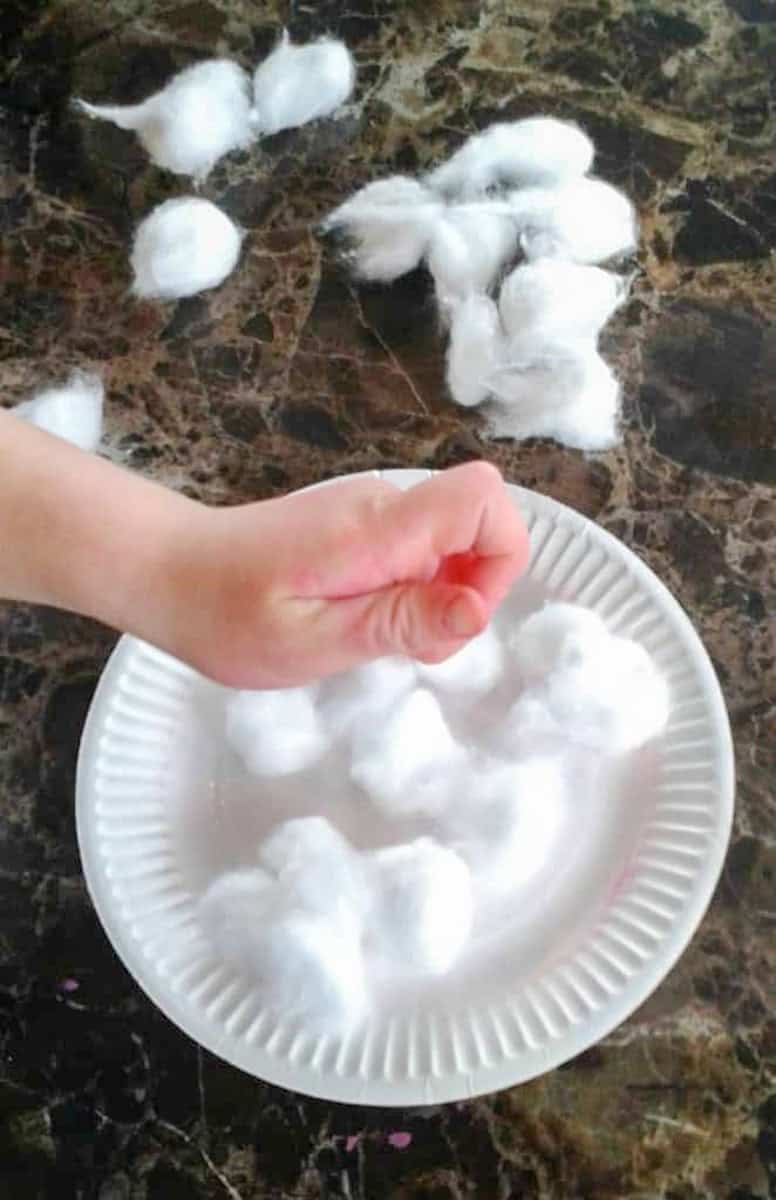 cotton balls on paper plate with hand