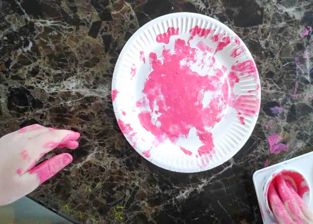 a paper plate on a counter painted with pink paint
