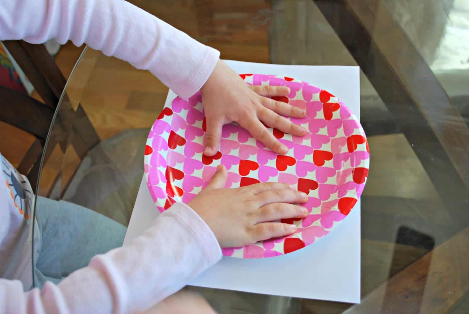 child making craft with paper plate