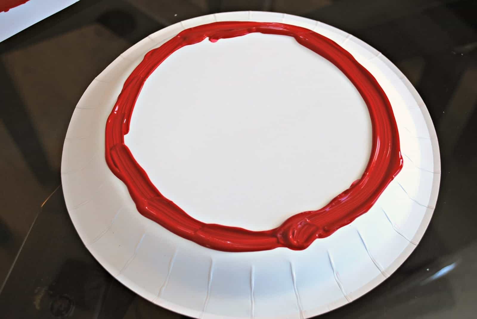 red paint on paper plate