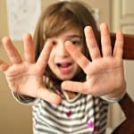 child holding up their hands