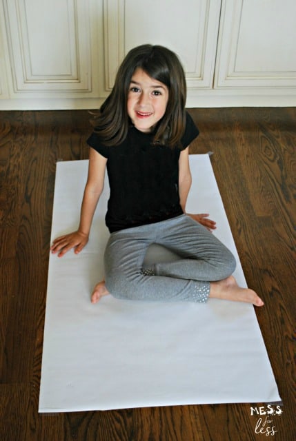 child sitting on easel paper
