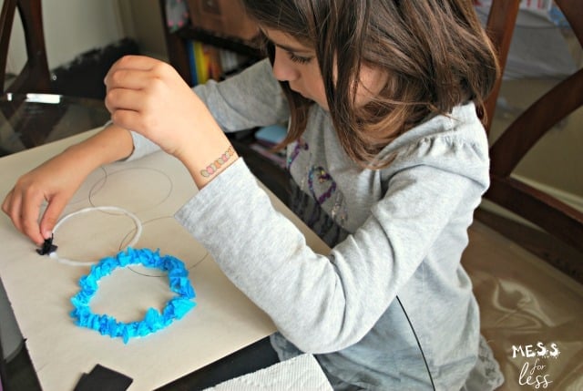 child making olympic rings craft
