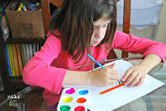 child painting popsicle sticks