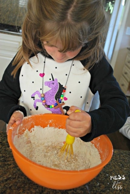 child stirring ingredients in a bowl