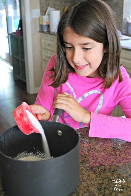 child pouring sugar in pot