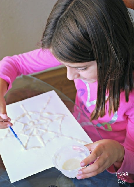 child painting watercolor spider webs