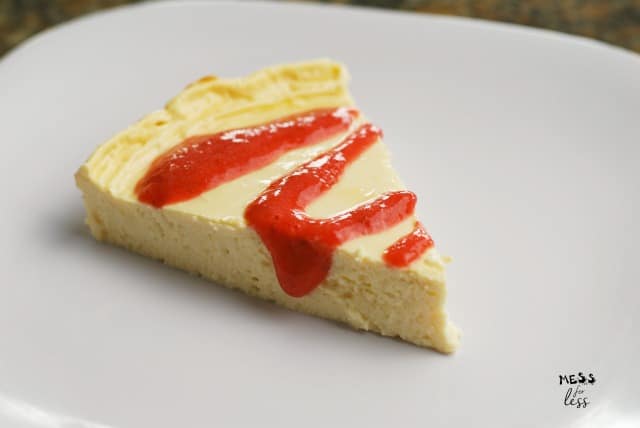slice of one point cheesecake with strawberry drizzle