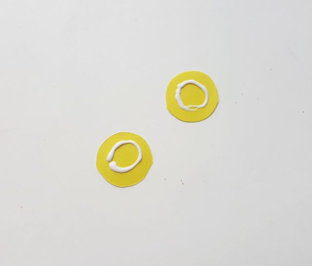 circles of yellow paper with glue on them
