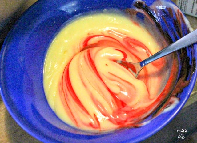 adding red food coloring to vanilla pudding