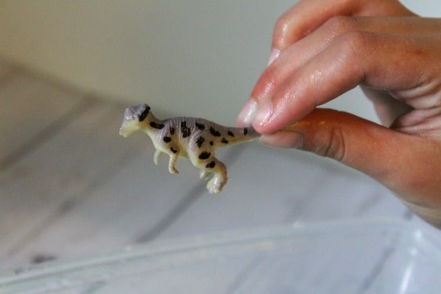 holding a dinosaur toy
