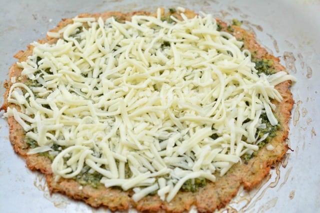 adding mozzarella to a pesto pizza