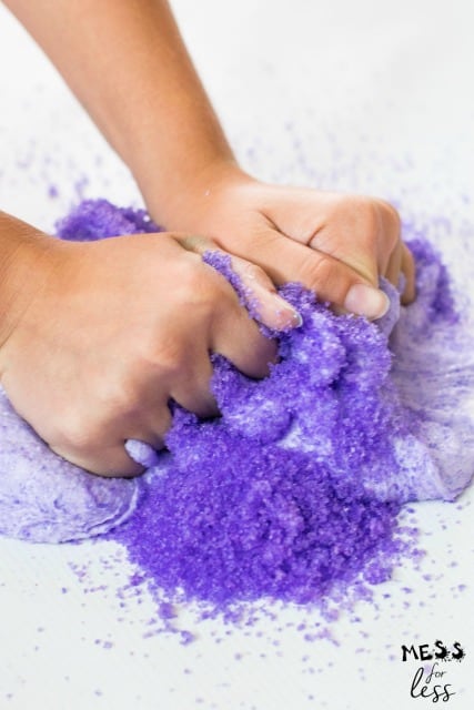 hands kneading purple snow into slime