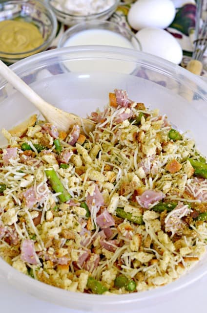 stuffing mix, ham, asparagus and cheese in a bowl being mixed