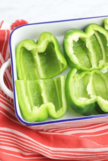 halved green peppers in a baking dish