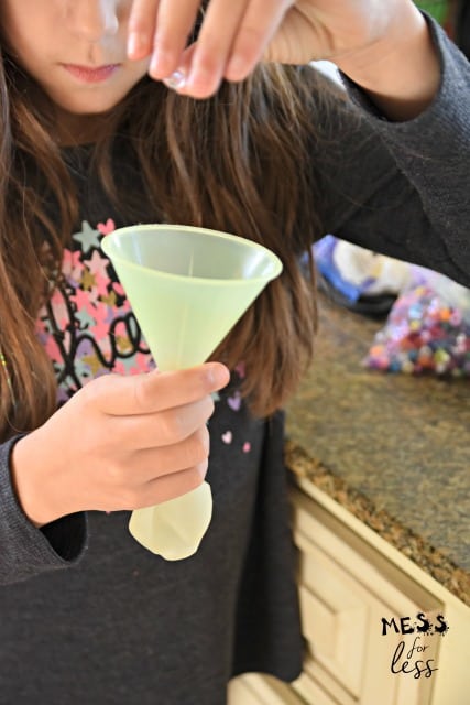 child dropping beads into a funnel