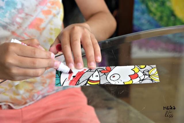 child coloring a bookmark with markers