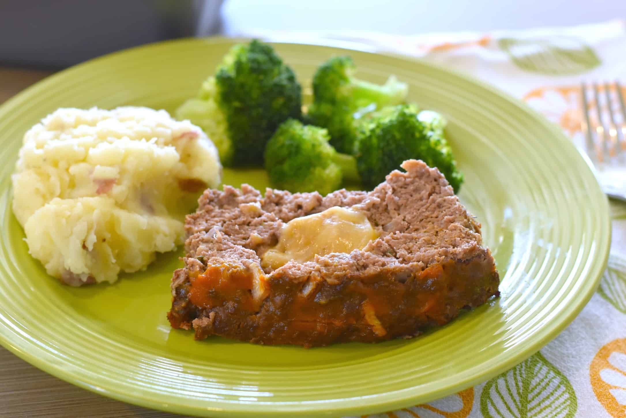 slice of cheeseburger meatloaf with mashed potatoes and broccoli