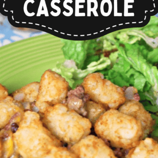 A delicious serving of ground beef tater tot casserole sits invitingly on a green plate, perfectly paired with fresh leafy greens.