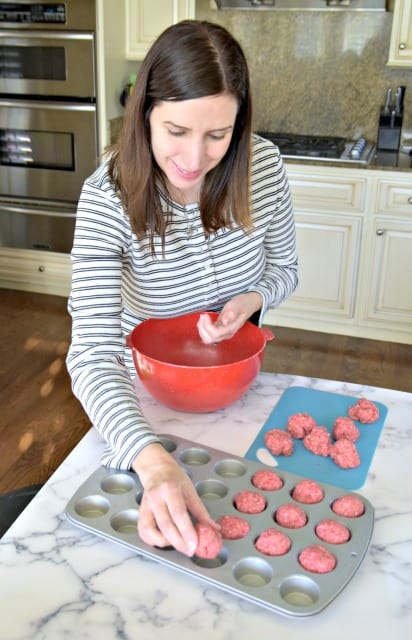 placing meatballs in a muffin tin