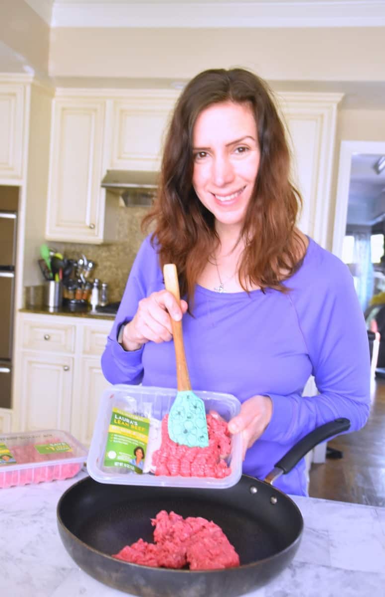 woman holding a package of laura's lean ground beef
