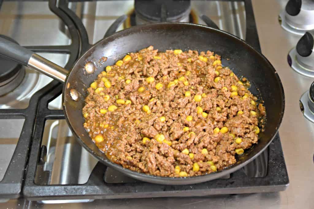 beef and corn cooking in a skillet