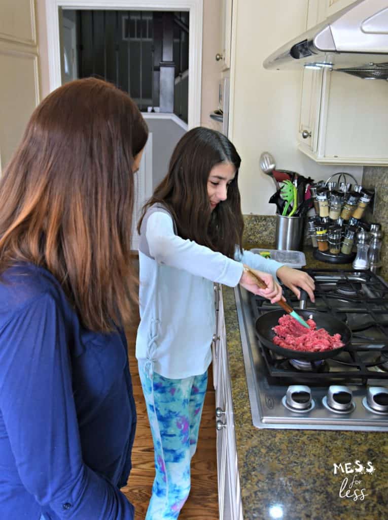 family cooking beef in a skillet