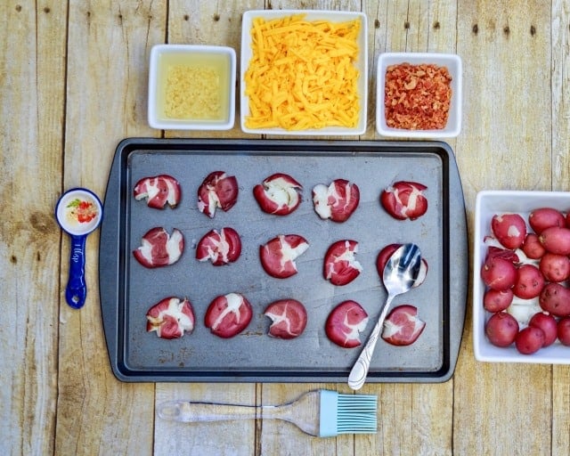 potatoes on baking sheet, cheese, bacon in bowls