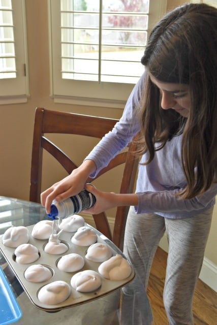 child squirting shaving cream into cups