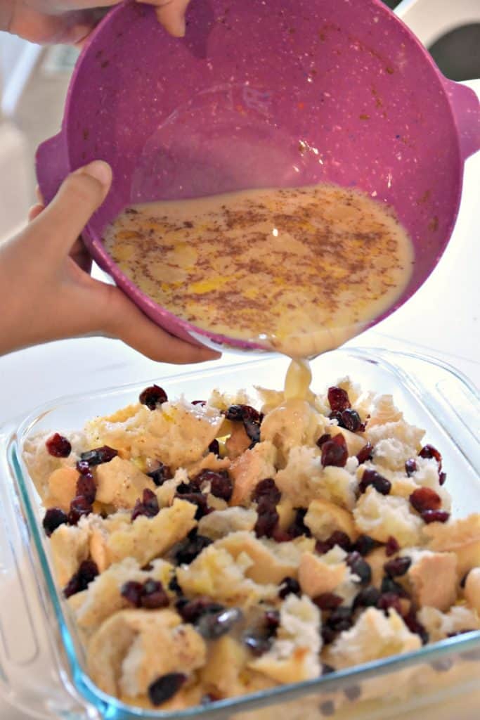 pouring egg mixture over bread pudding