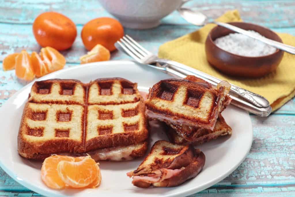 monte cristo sandwich on a plate with oranges