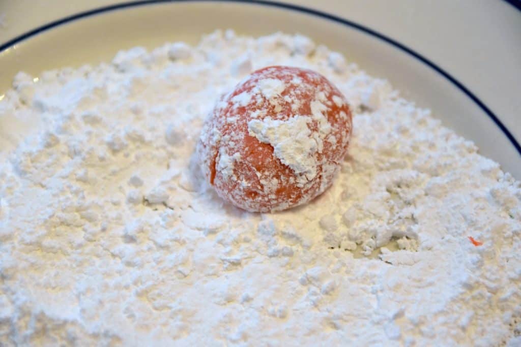 rolling cookies in powdered sugar