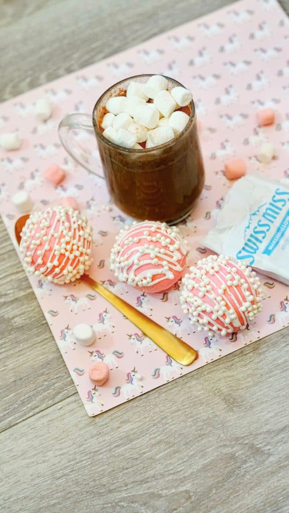 hot cocoa bombs and hot chocolate in a mug