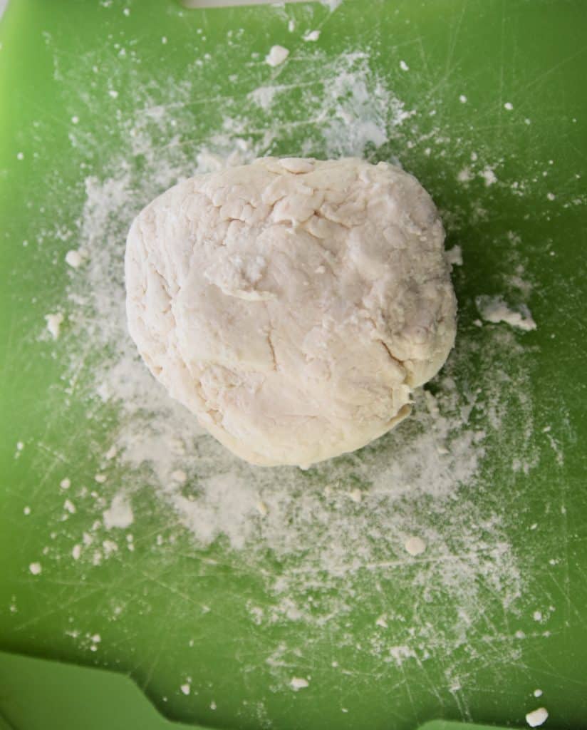 ball of flour on green cutting board
