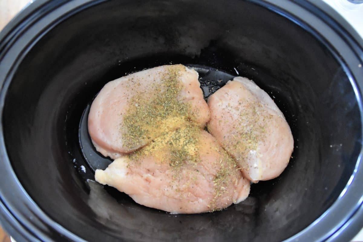 raw chicken and spices in a crock pot