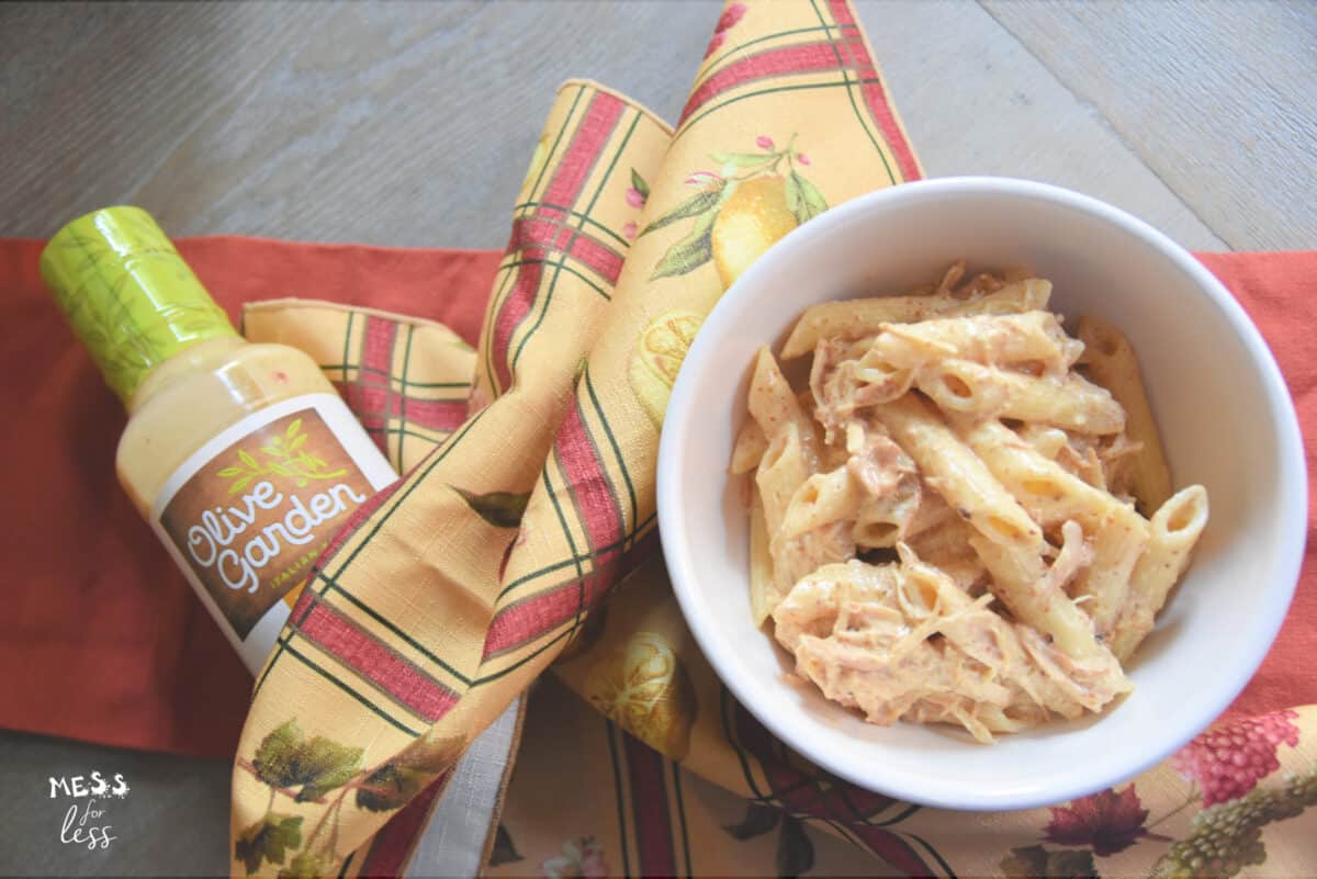 olive garden pasta and chicken in a bowl and a bottle of olive garden dressing