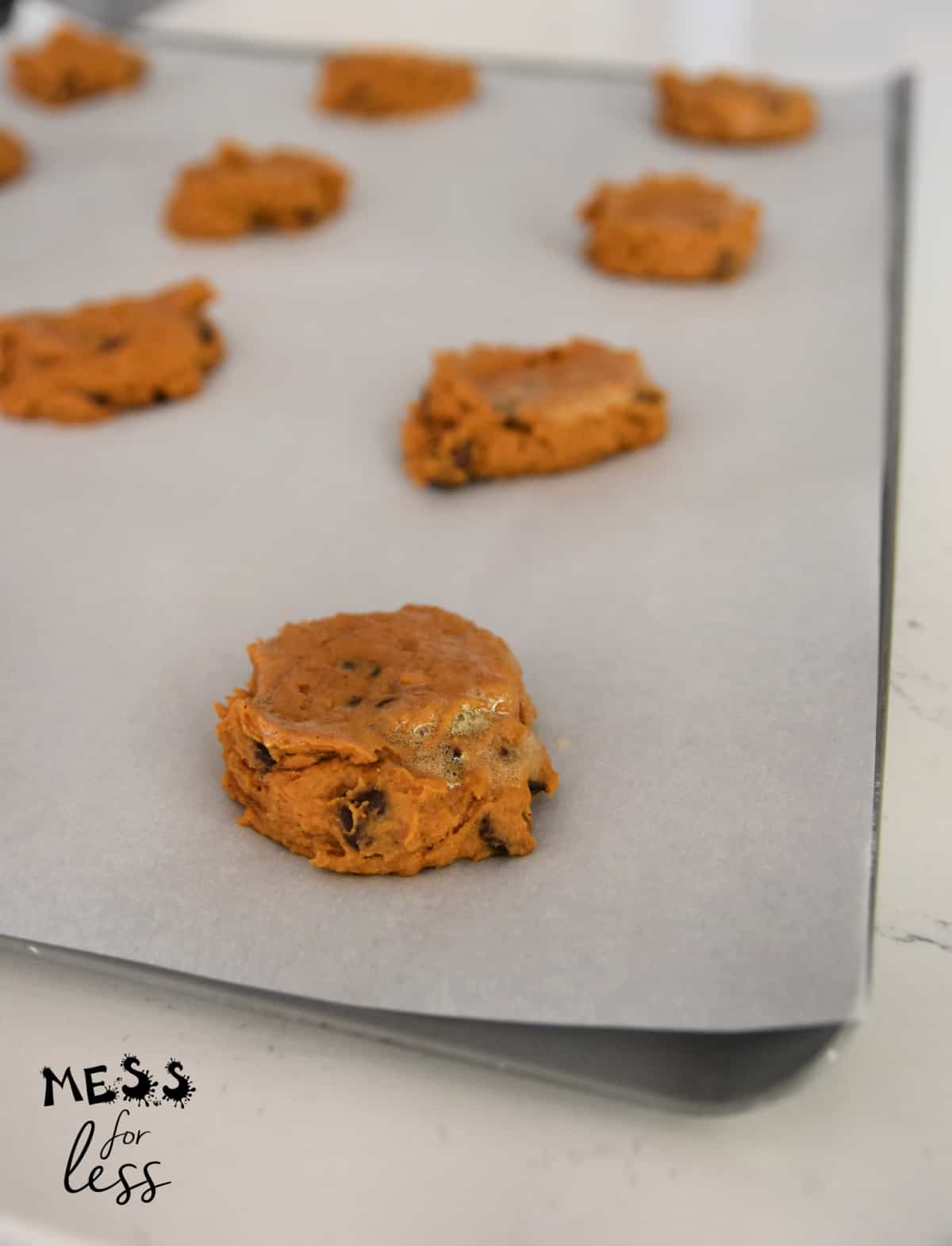 pumpkin chocolate chip cookies on a cookie sheet