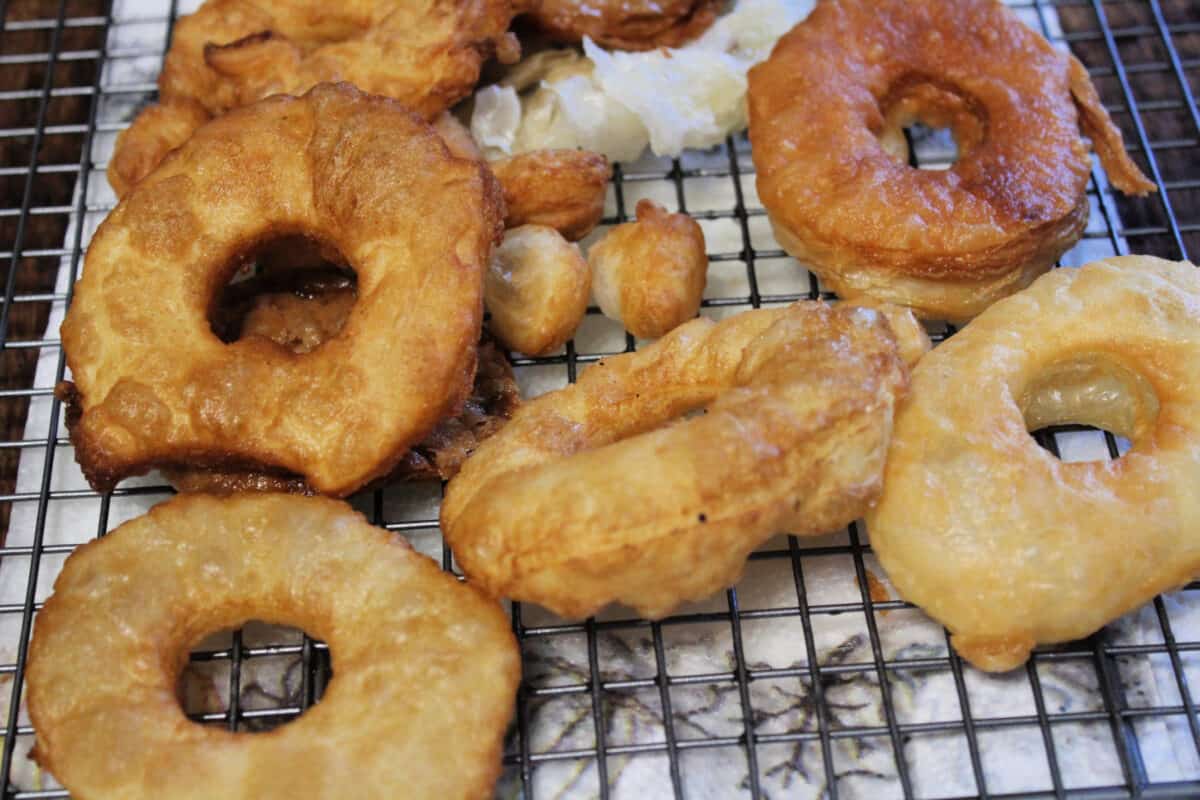 fried puff pastry donuts on a cooling rack