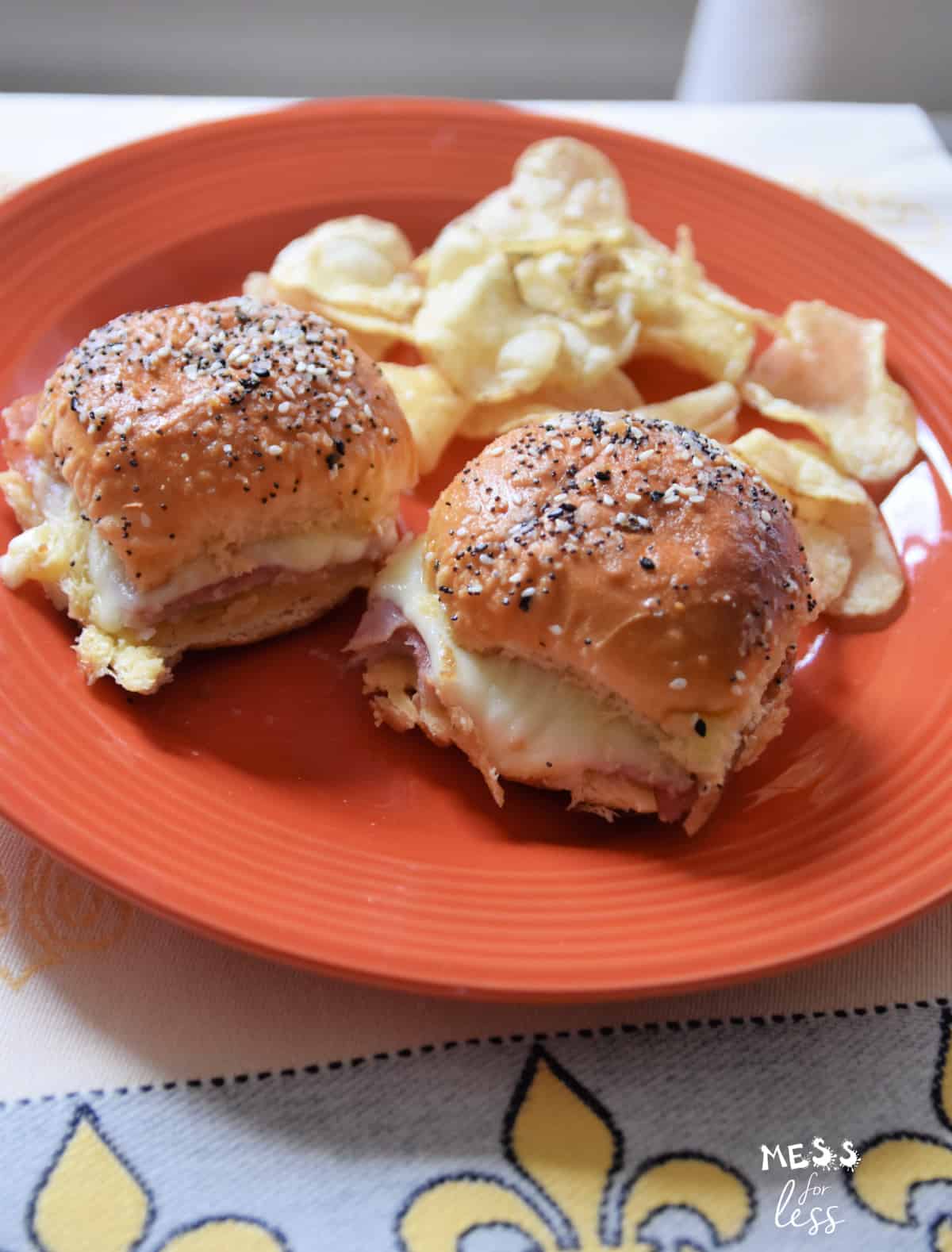 ham and cheese sliders on a plate with potato chips