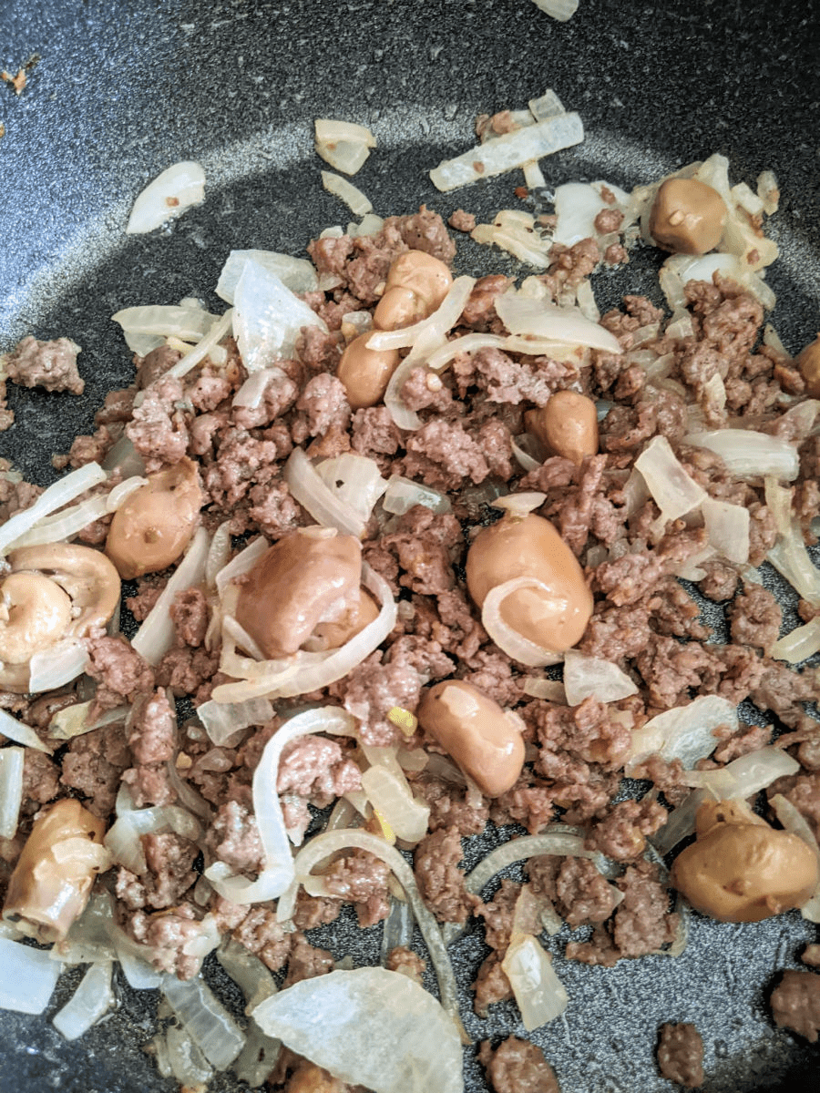 ground pork, onions and mushrooms in pan