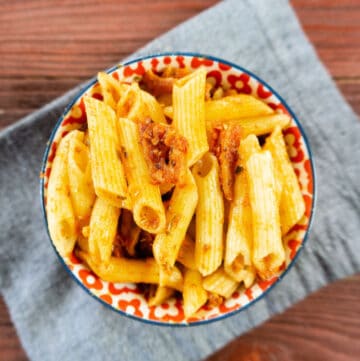 pasta with sundried tomato pesto and pancetta in bowl