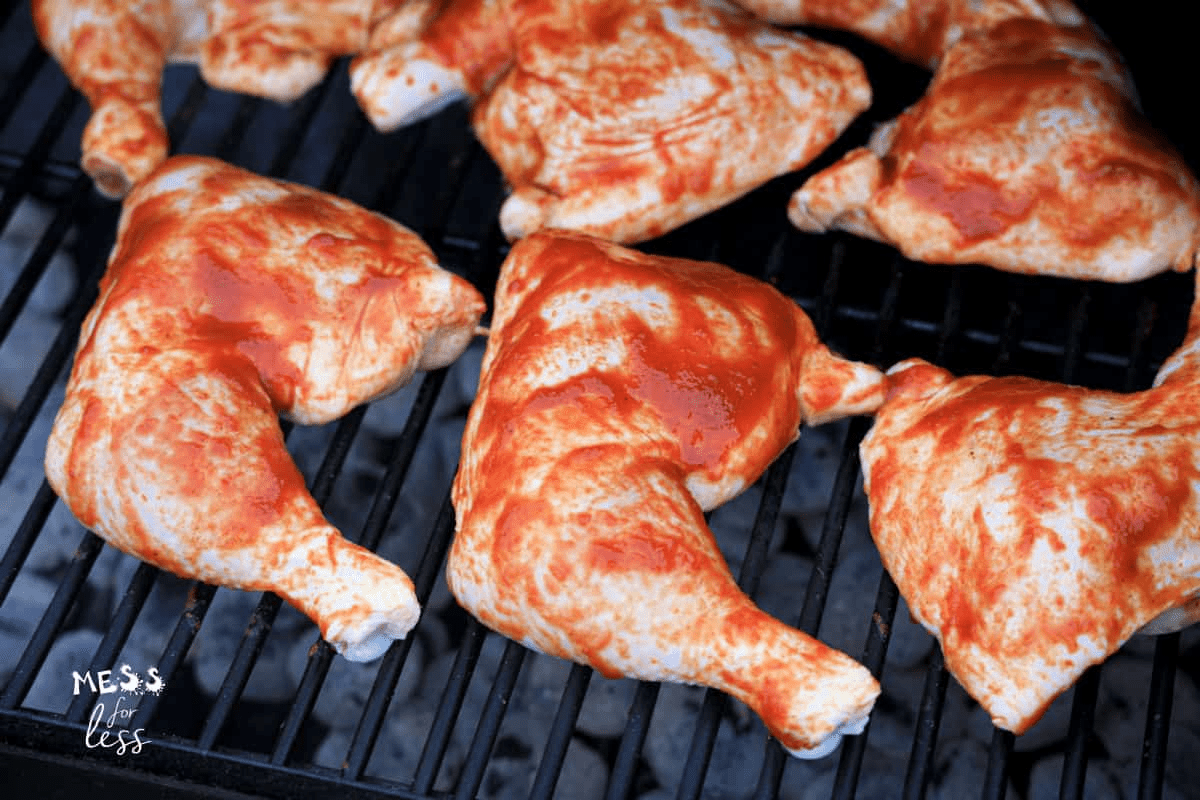 chicken leg quarters on grill with bbq sauce
