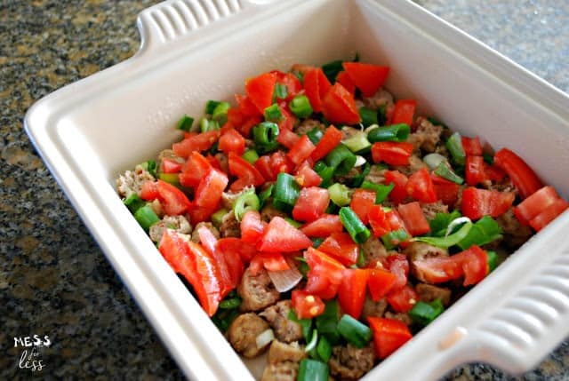 baking dish with sausage, tomatoes and green onions