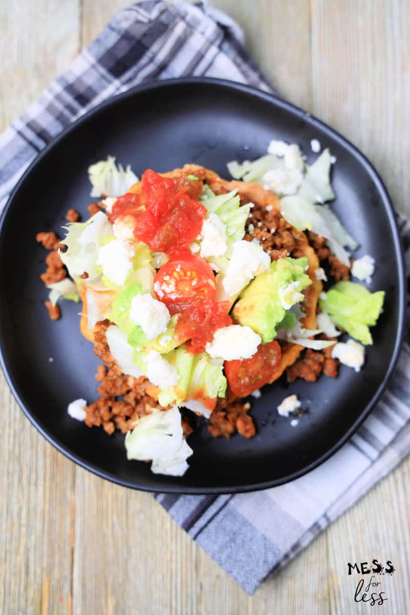 Mexican sopes recipe topped with beef, tomatoes, avocado and cheese