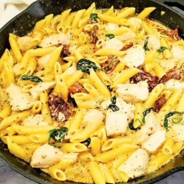 cropped creamy tuscan chicken and pasta in skillet