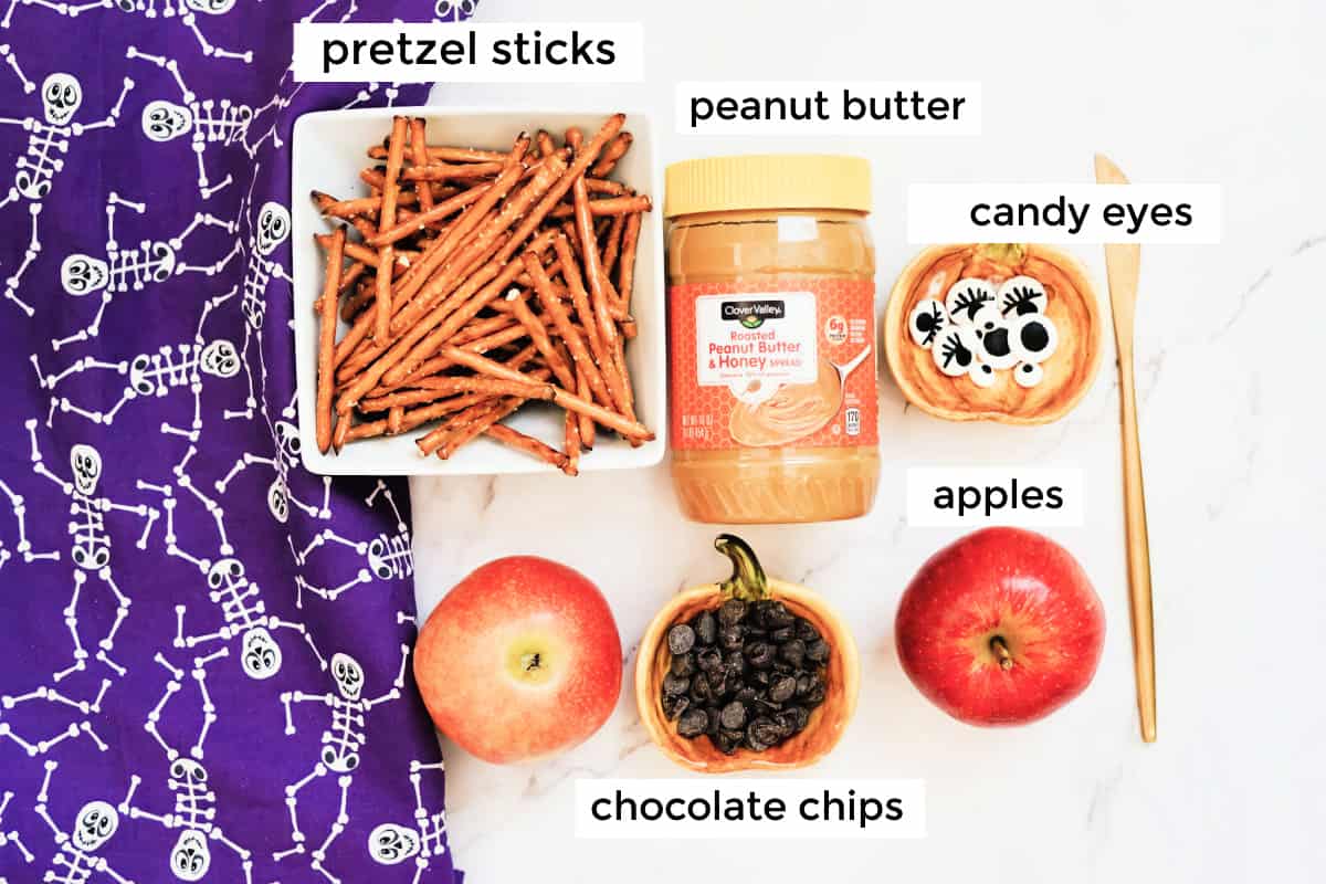 pretzel sticks, peanut butter, candy eyes, apples, chocolate chips