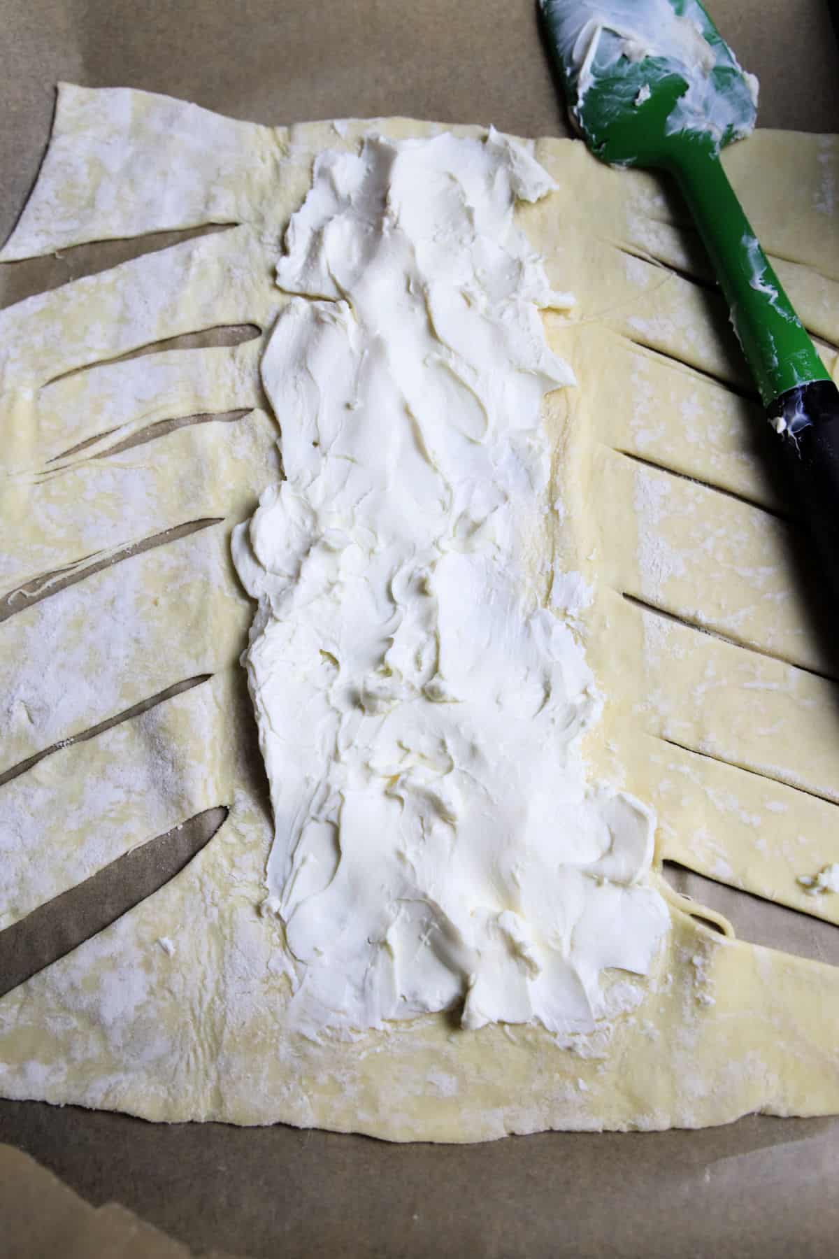 puff pastry dough with slits cut in side and cream cheese