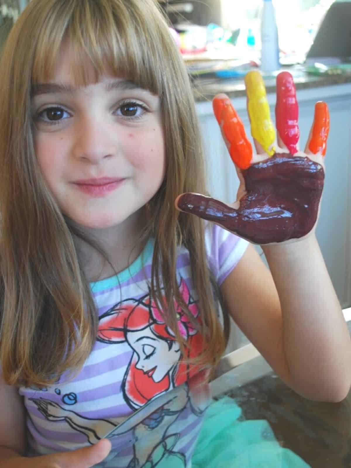 child holding up painted hand.