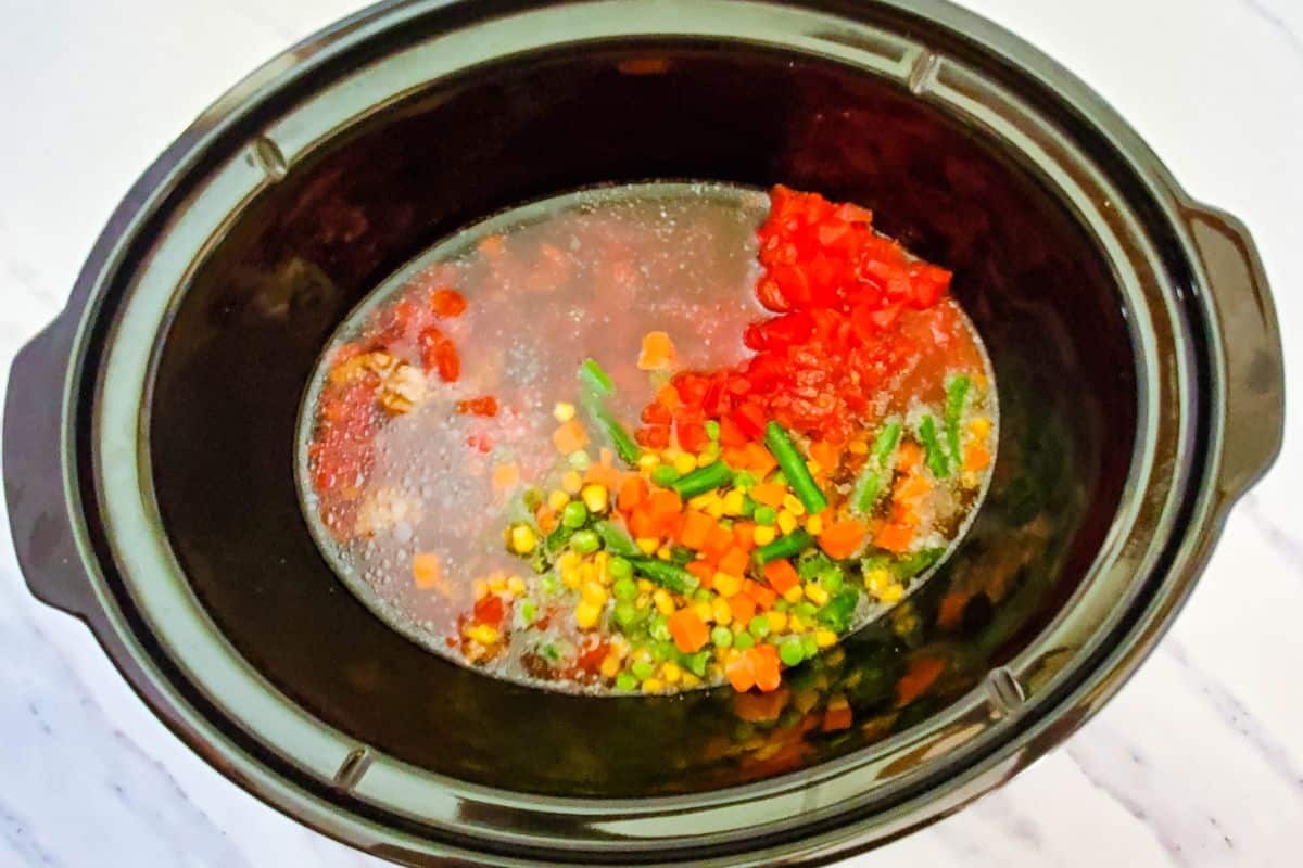 crockpot with beef, veggies, broth and tomatoes.