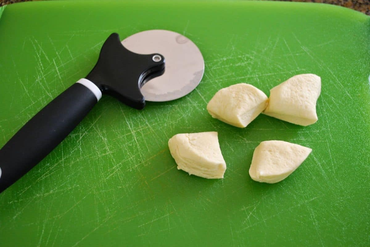 dough on cutting board with pizza cutter